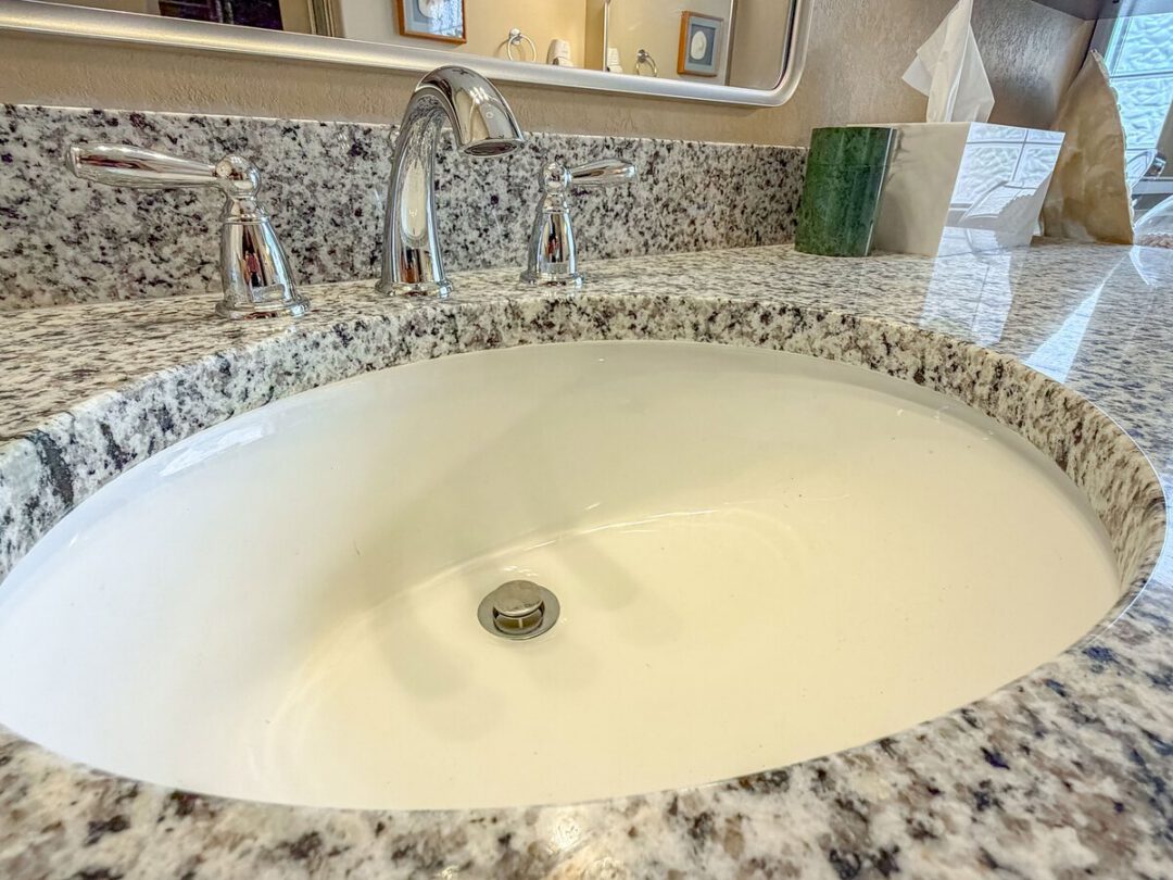 Vanity countertop with an undermount sink and a chrome widespread faucet