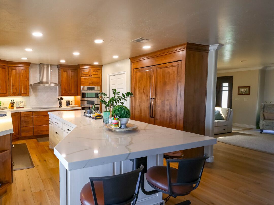 Quartz kitchen island with seating for four and a stainless vent hood behind